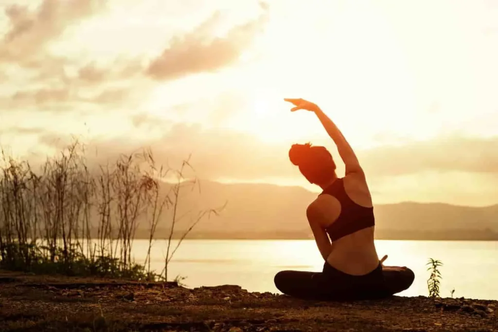 Yoga au lever du soleil, posture d’étirement latéral favorisant la souplesse, l’ouverture du flanc et l’ancrage corporel.