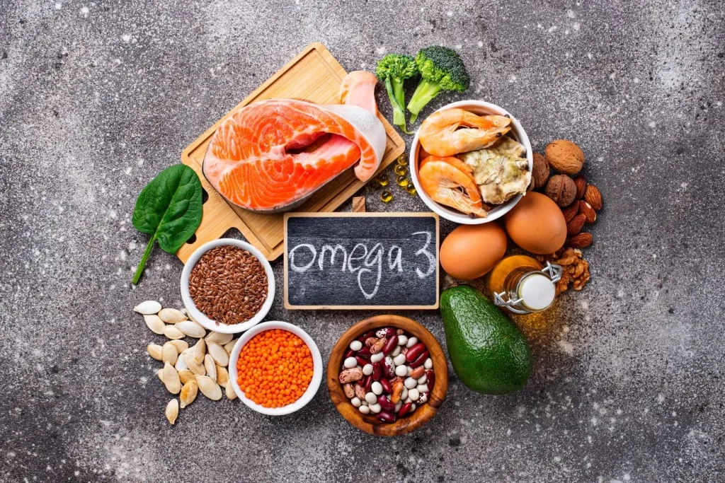 Saumon, crevettes, graines et légumes réunis sur fond gris, image typique d’un apport en oméga-3