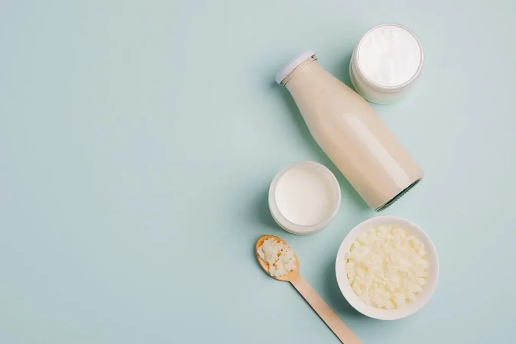 Produits laitiers fermentés posés sur une surface claire, image évoquant les bienfaits digestifs et immunitaires des laits fermentés