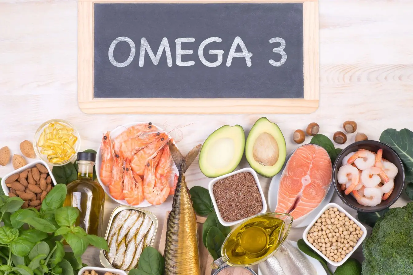 Aliments riches en oméga-3 disposés autour d’un tableau noir, image illustrant leurs bienfaits nutritionnels.