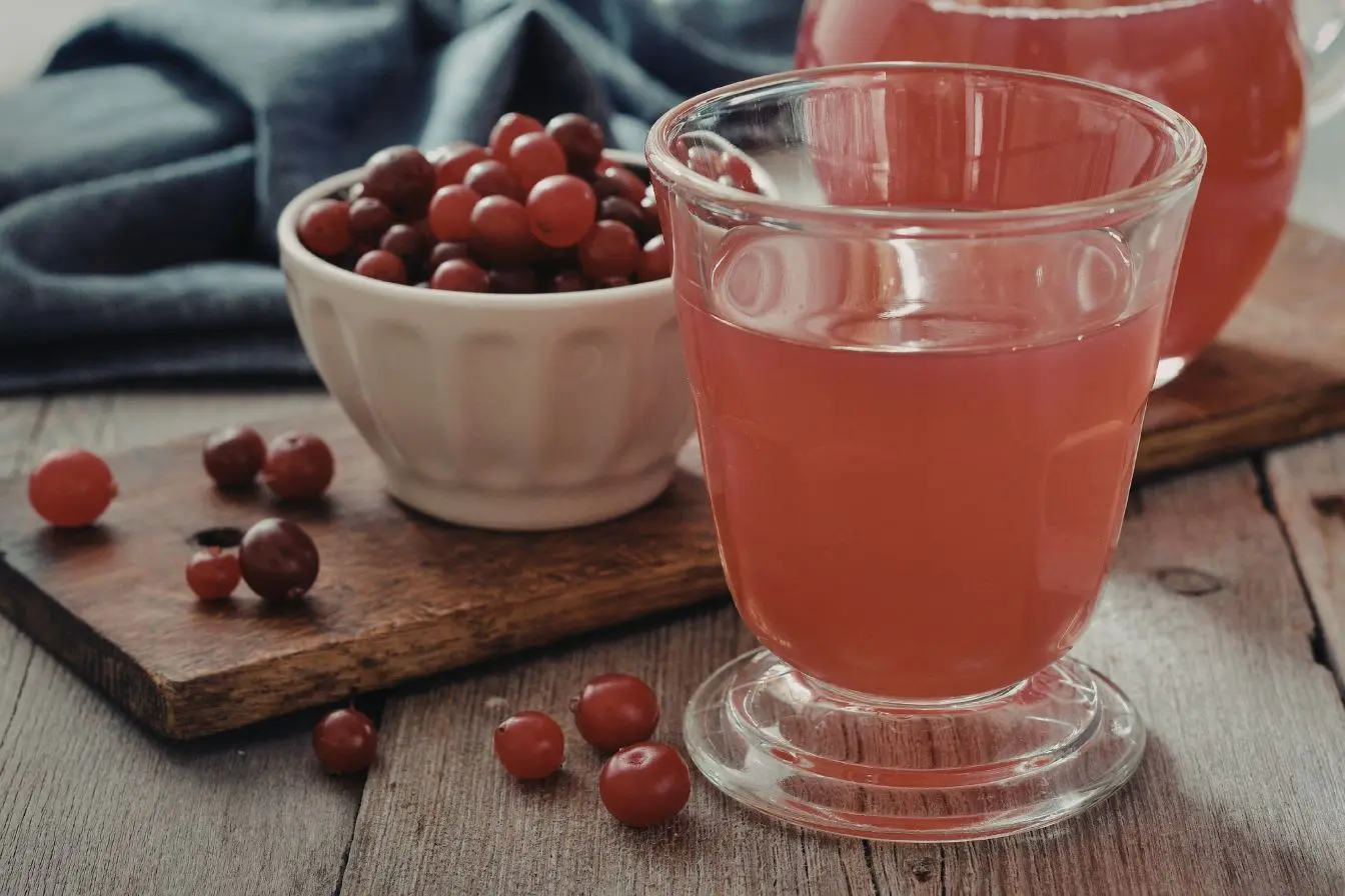 Verre de jus de cranberry posé sur une table en bois, image illustrant ses bienfaits antioxydants