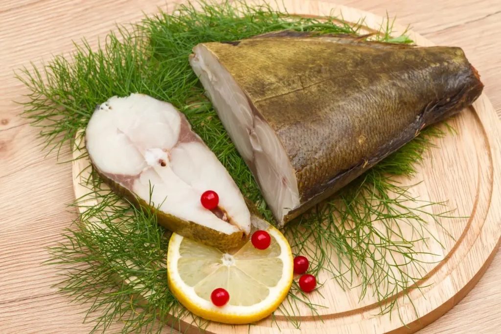 Filet de poisson fumé sur planche en bois avec citron, baies rouges et aneth, source naturelle d’oméga-3