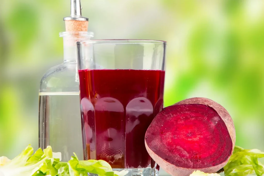 Jus de betterave rouge vif entouré de légumes frais, image d’un élixir santé riche en nutriments