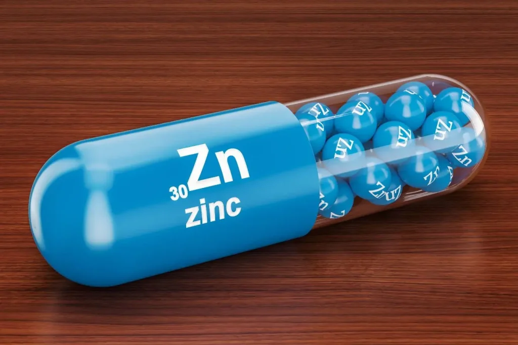Capsule bleue transparente marquée Zn contenant des sphères bleues, image illustrant le picolinate de zinc utilisé comme complément alimentaire essentiel