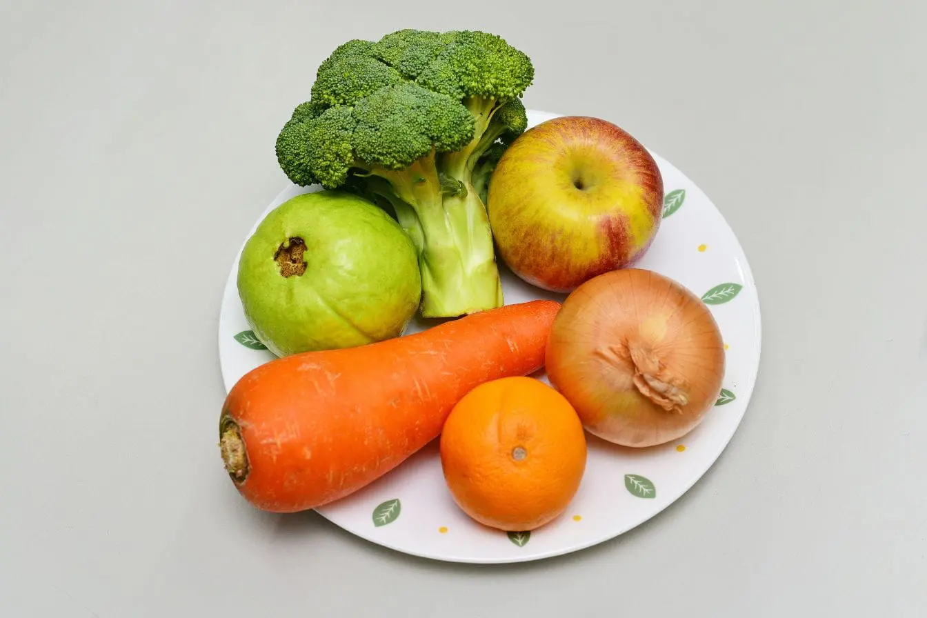 Assiette garnie de légumes et fruits variés, image illustrant la chrononutrition qui recommande de consommer chaque aliment au moment optimal de la journée.