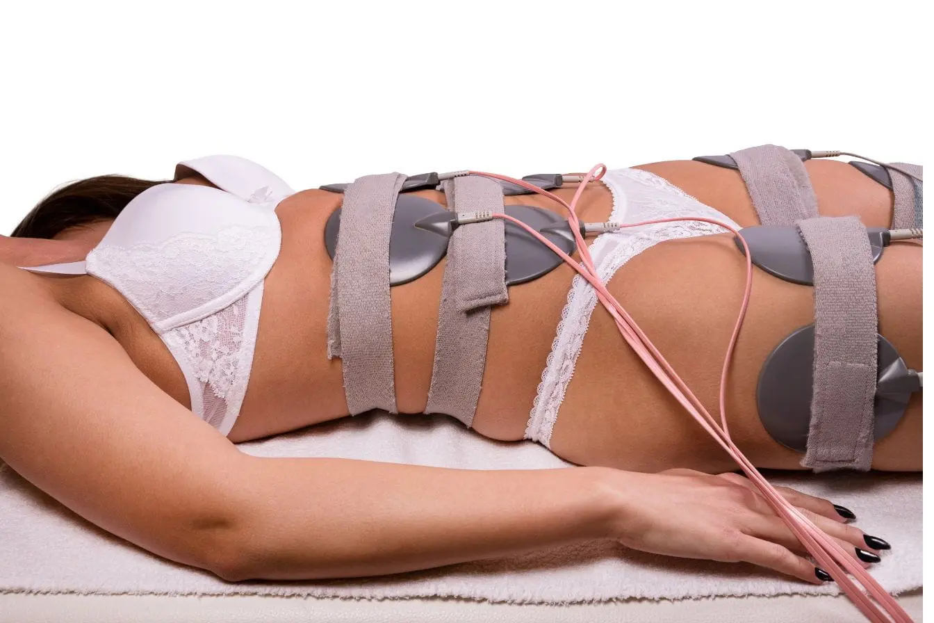 Personne allongée avec électrodes sur l’abdomen, illustrant l’efficacité de l’électrostimulation pour tonifier la ceinture abdominale et renforcer les muscles.
