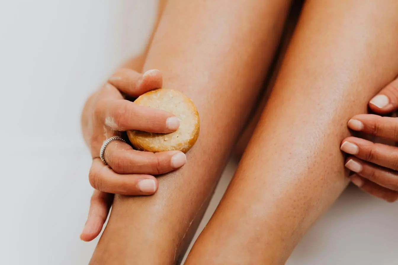 Gros plan sur des jambes massées avec un galet cosmétique, image illustrant un soin apaisant pour soulager la sensation de jambes lourdes.