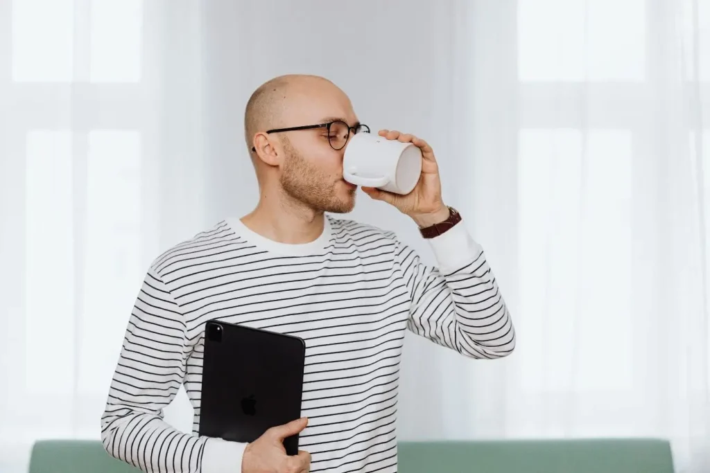 Portrait d'un homme buvant dans un mug blanc illustrant la consommation quotidienne de kéfir de lait ou kéfir d'eau
