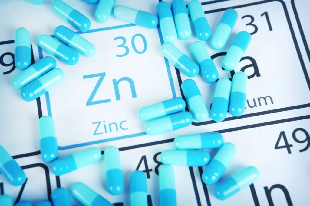Tableau périodique mettant en avant le zinc entouré de capsules bleues, image illustrant le picolinate de zinc comme complément nutritionnel essentiel