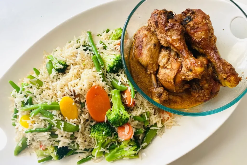 Assiette avec riz aux légumes et poulet en sauce, image évoquant une alimentation équilibrée riche en nutriments pour prévenir l’ostéoporose.