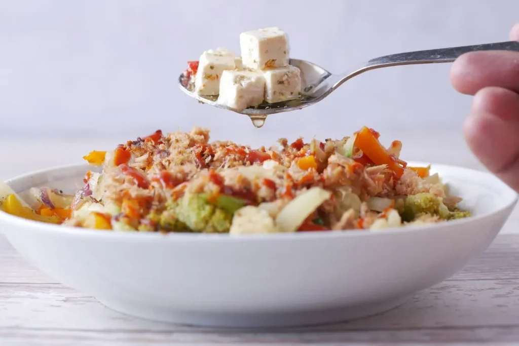 Gros plan sur repas équilibré avec légumes et tofu, image représentant différence entre faim qui nourrit et appétit qui attire par envie culinaire.