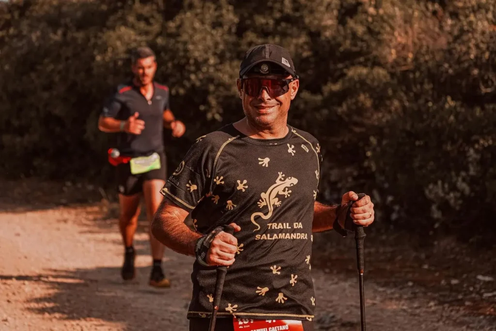 Participant sur sentier forestier avec bâtons de marche, image illustrant la marche nordique et l’activité physique en pleine nature.