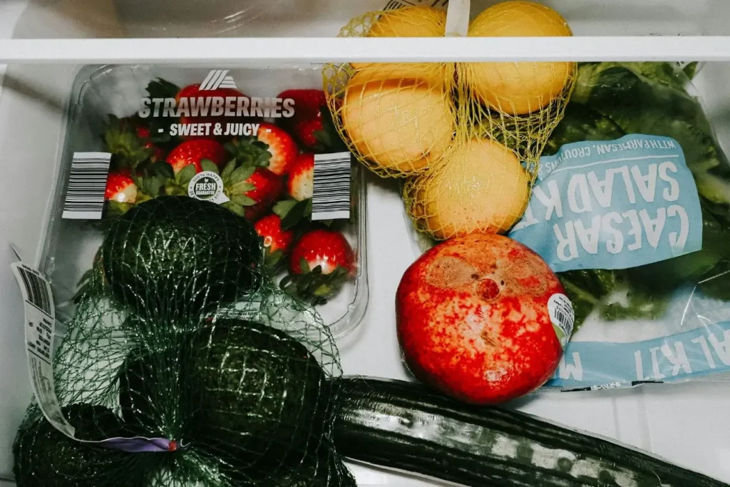 Fruits et légumes variés dans bac de frigo, symbole de la conservation optimale et du respect des durées pour éviter le gaspillage alimentaire.