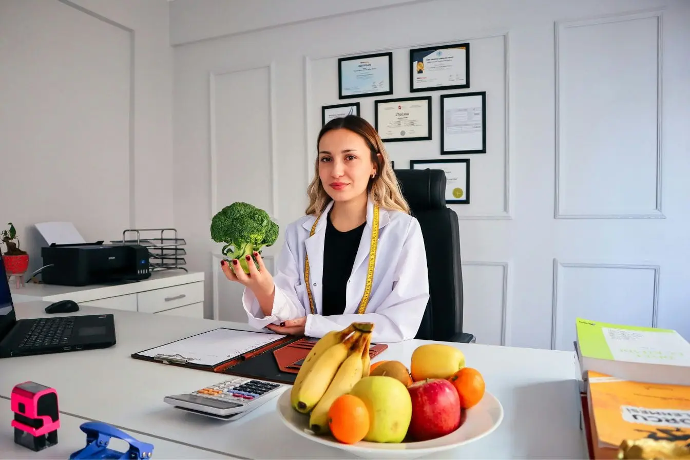 Bureau médical avec fruits frais et ordinateur, symbole de la prévention des maladies rénales par une alimentation adaptée.