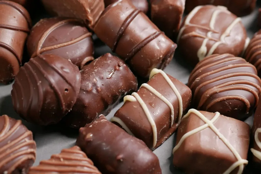 Assortiment de chocolats variés aux décorations fines, image évoquant une alimentation anti‑stress qui apporte plaisir et détente.