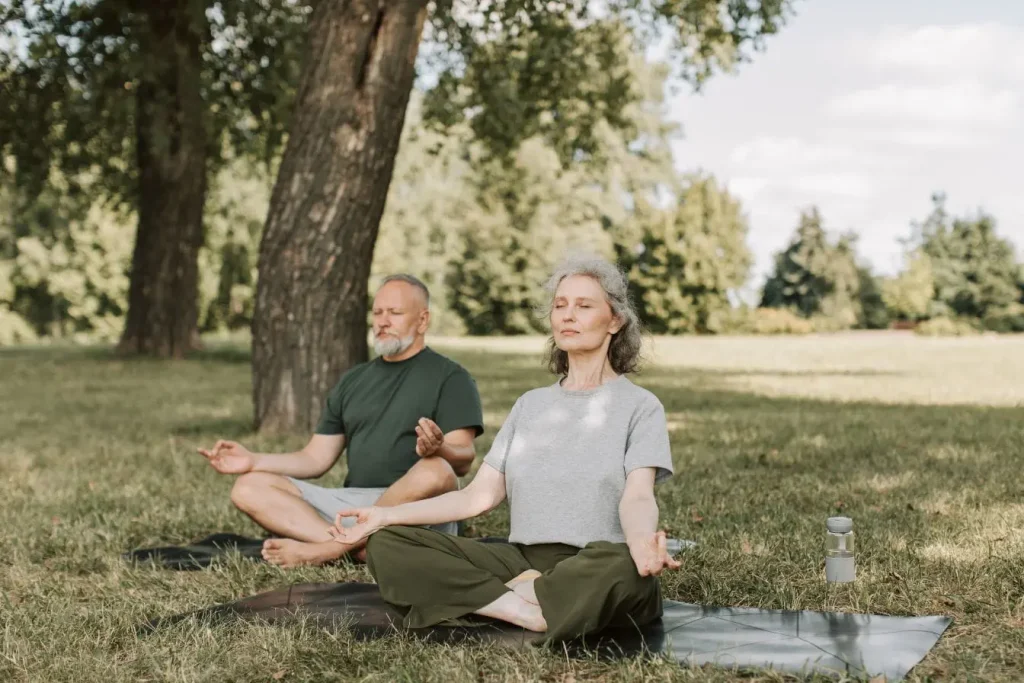Scène de méditation dans herbe verte, image représentant la pleine conscience pour débutant comme pratique apaisante.