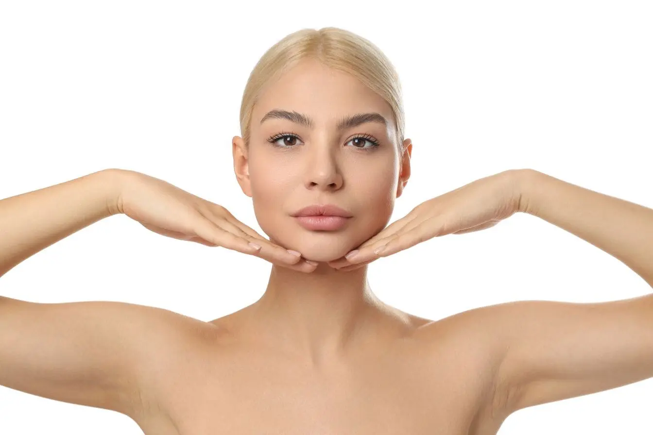 Personne posant les mains sous le visage, illustrant l’importance d’une alimentation riche en fruits et légumes pour une peau éclatante et lumineuse.