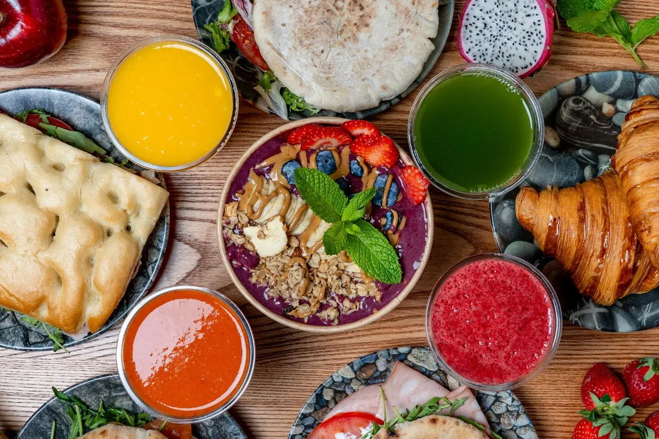 Assortiment de jus frais et fruits rouges autour d’un bol, reflet d’une nutrition équilibrée qui contribue à réduire les triglycérides.