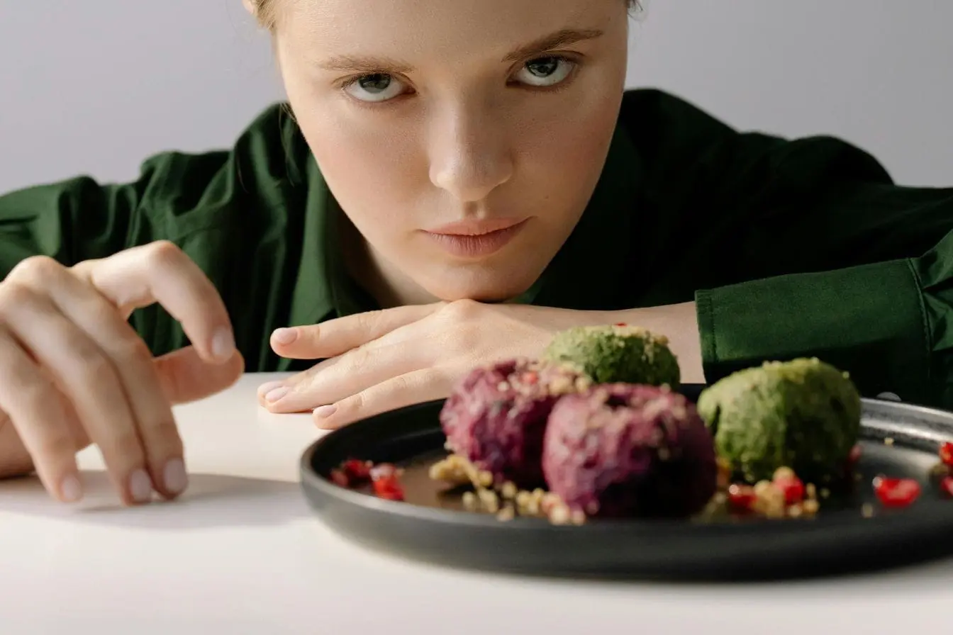 Graines et fruits rouges Assiette de boules colorées reflétant la vigilance nécessaire pour éviter certains aliments aggravant l’eczéma et préserver la peau.