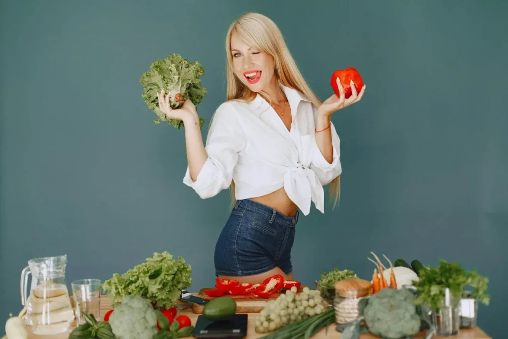 Personne debout derrière une table remplie de légumes frais et fruits, image illustrant les aliments naturels privilégiés dans un régime cétogène.