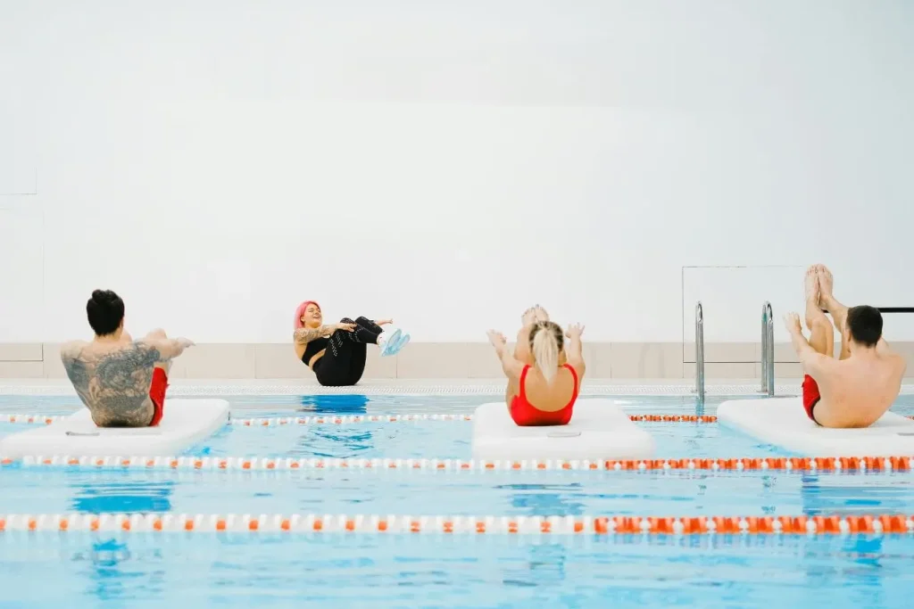 Trois personnes en position gainage sur tapis, image représentant aquagym et calories brûlées dans séance dynamique.