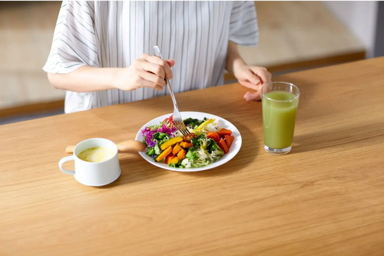 Assiette colorée de légumes variés avec jus vert et soupe, image qui illustre l’importance de l’alimentation pour prévenir la calcification artérielle.