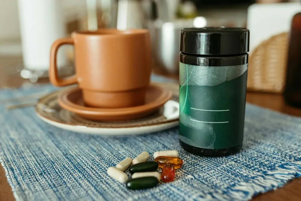Tasse en céramique brune posée sur napperon bleu avec gélules colorées, image qui illustre le lien entre alimentation et concentration adulte.