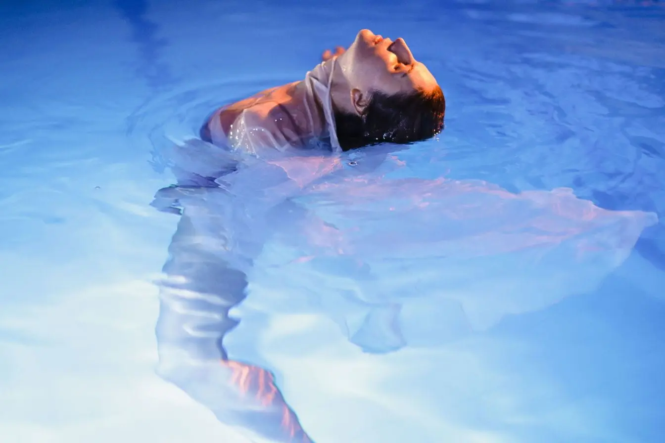 cryothérapie Personne immergée dans eau froide vêtue d’un tissu léger, image illustrant les effets de la cryothérapie.