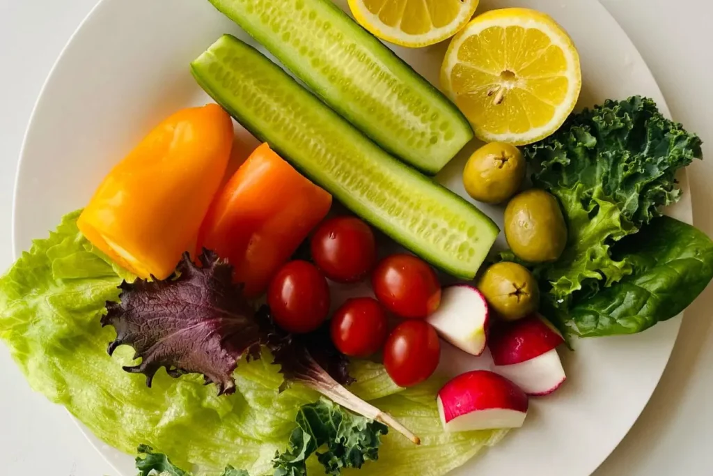 Assiette colorée de légumes et fruits frais, image qui illustre le rôle d’une alimentation variée et équilibrée dans la longévité.