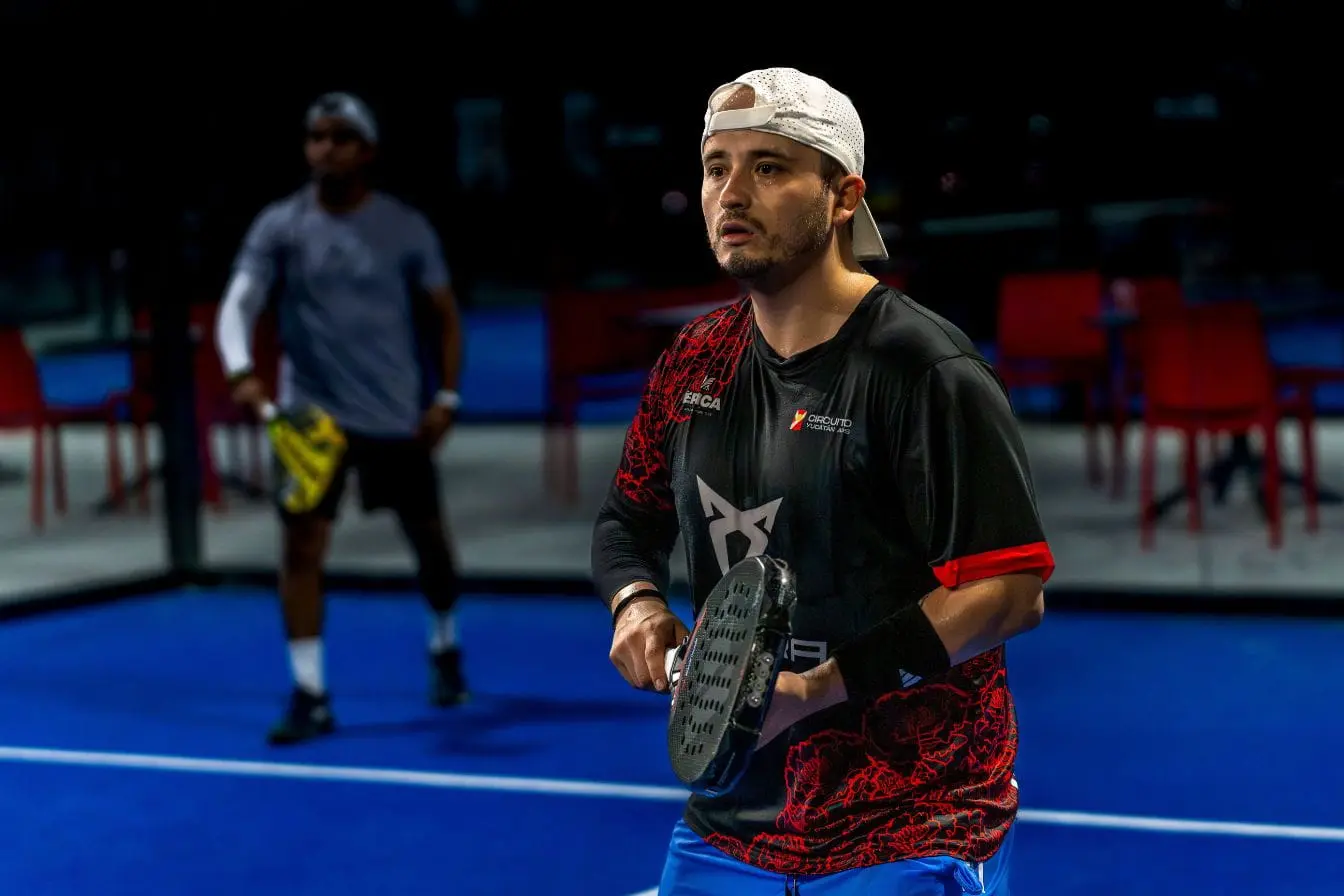 padel Joueurs concentrés sur terrain bleu de padel, image illustrant l’intensité physique et les calories brûlées pendant le match.