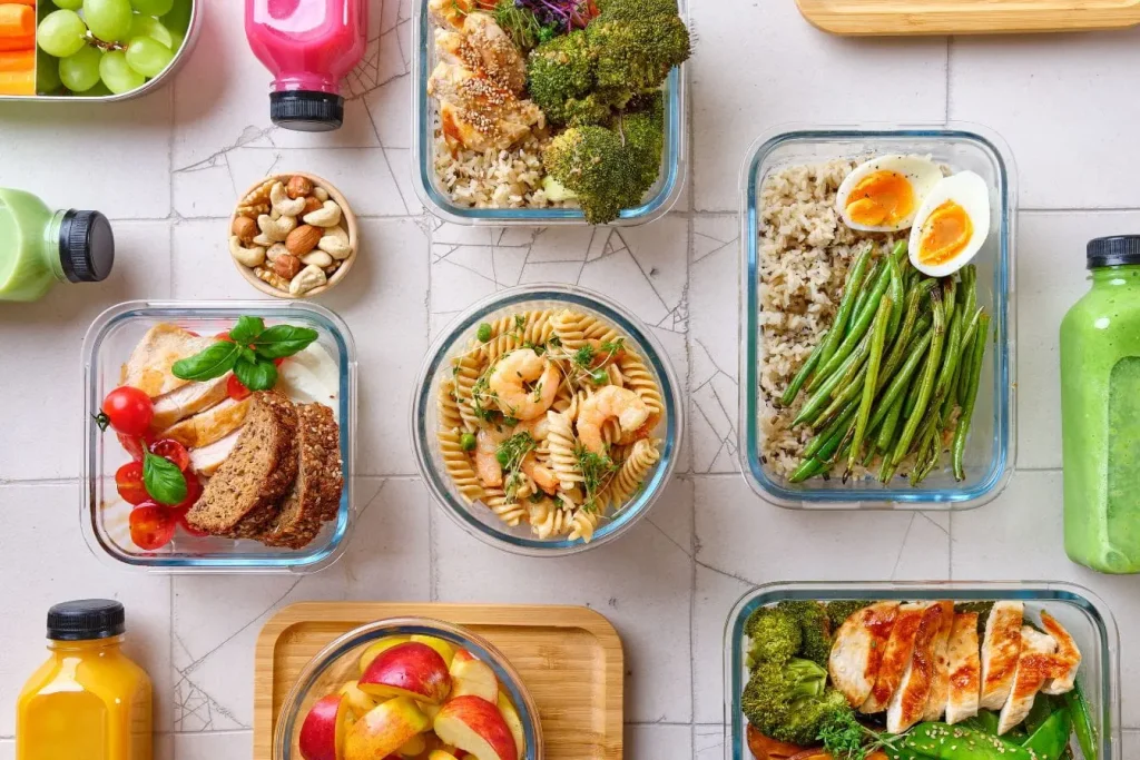 Ensemble de repas équilibrés préparés dans boîtes transparentes, image illustrant l’importance de l’alimentation saine après accouchement.