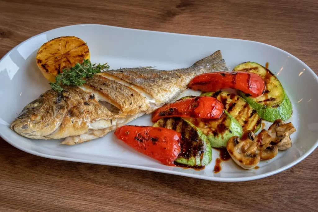Assiette de poisson grillé accompagné de légumes, image qui illustre l’importance d’une alimentation équilibrée pour soulager la polyarthrite rhumatoïde.