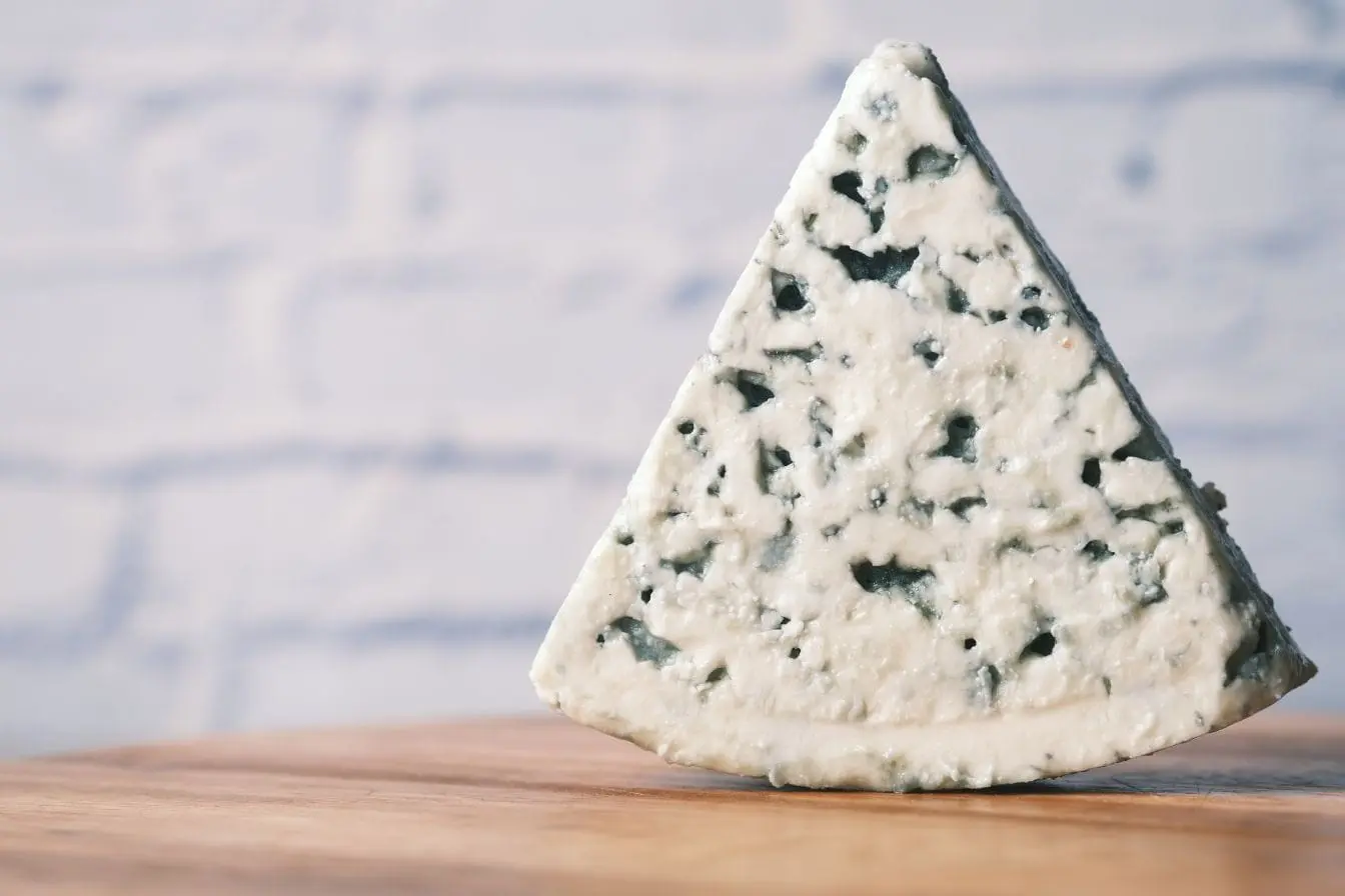 Fromage bleu veiné de moisissures Gros plan sur fromage marbré de bleu-vert, image claire des dangers des moisissures alimentaires.