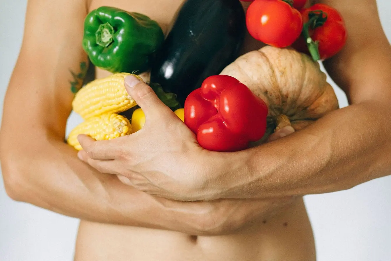 Personne tenant légumes colorés Personne tenant légumes colorés contre soi, image qui illustre le lien entre alimentation variée et fertilité masculine.