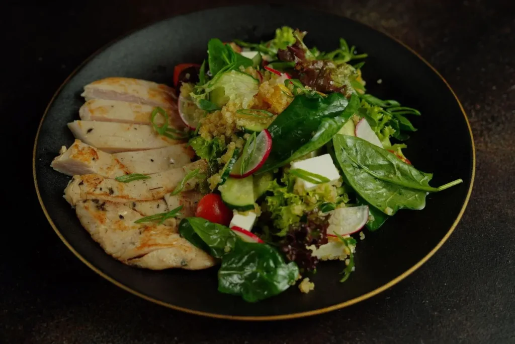 Assiette équilibrée avec poulet grillé et salade variée, reflet du lien entre alimentation saine et apnée du sommeil.