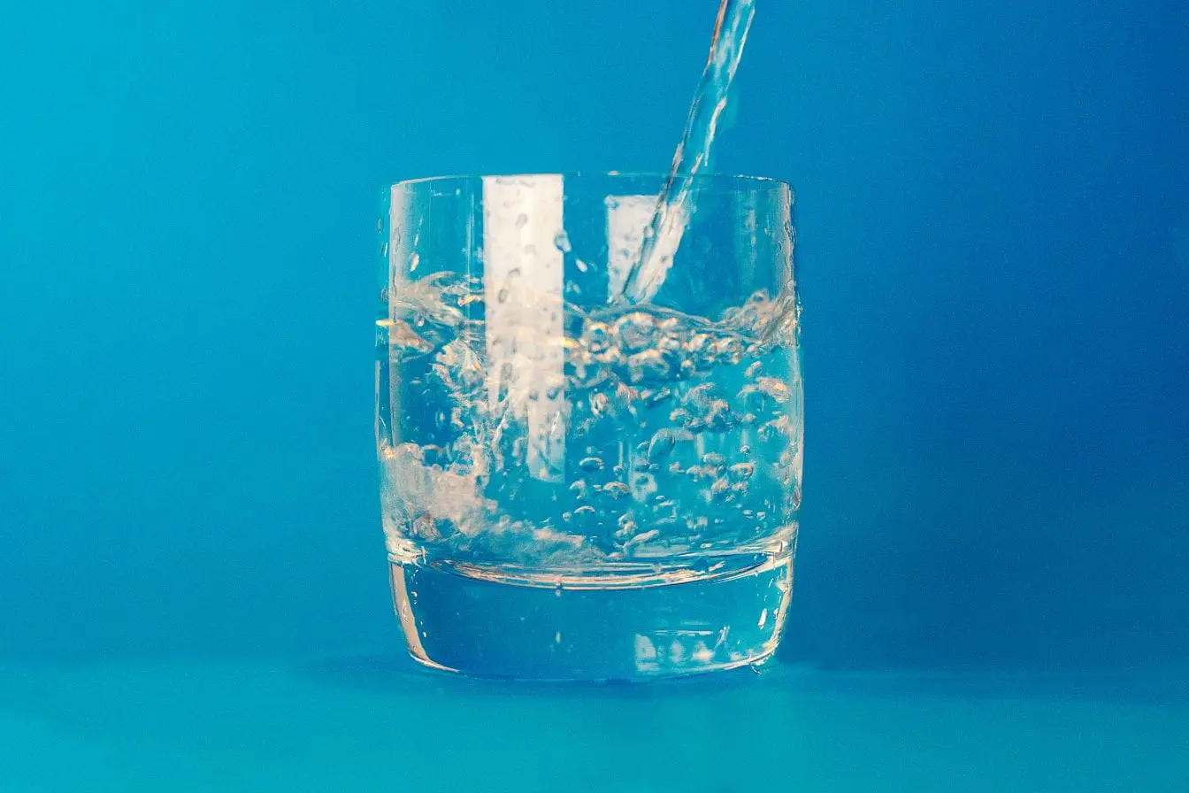 eau gazeuse Verre transparent rempli d’eau pétillante avec bulles visibles, image qui illustre les bienfaits et méfaits de l’eau gazeuse pour la santé.