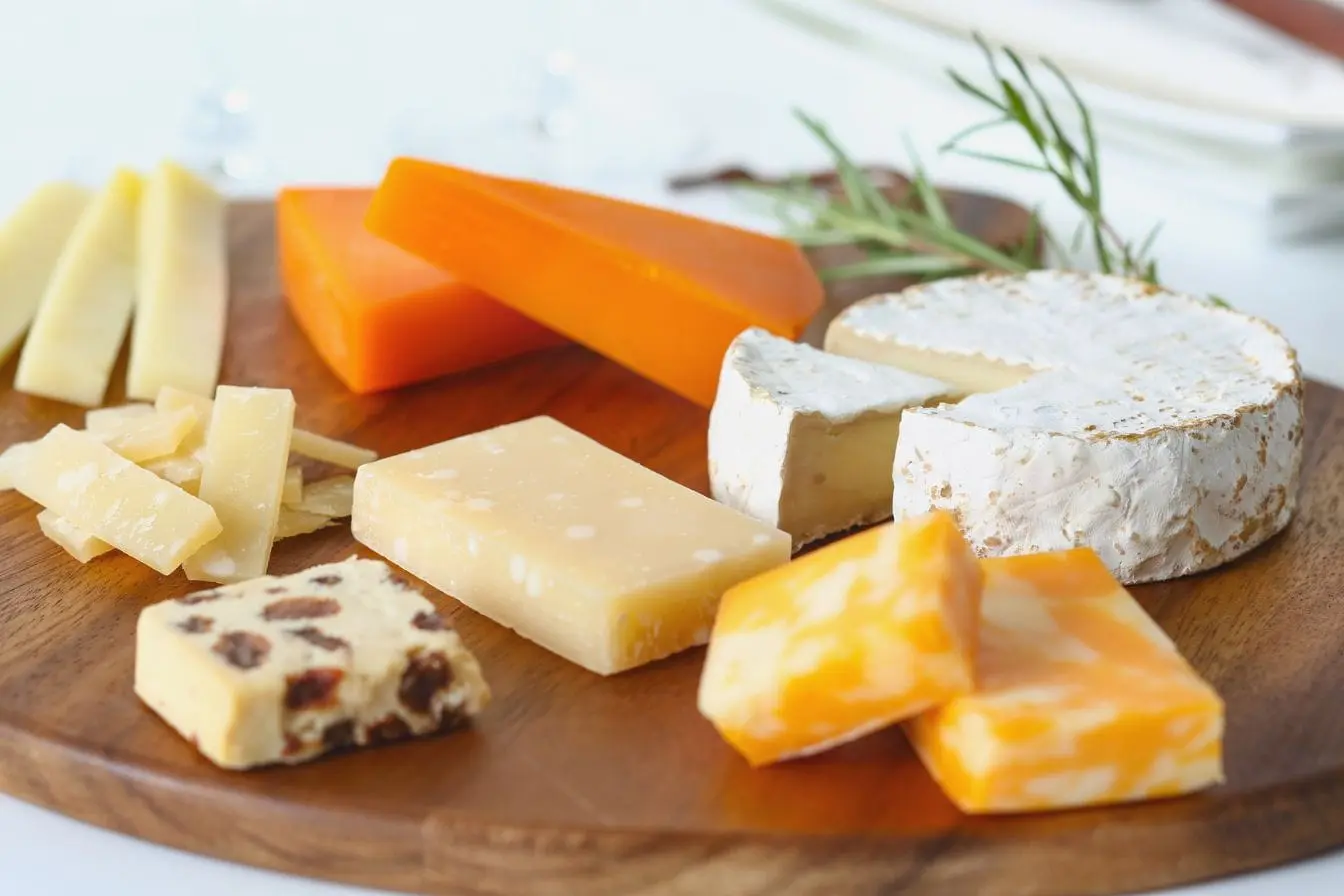 Plateau en bois garni de fromages variés, reflet d’une alimentation pouvant prévenir la carence en vitamine B12.