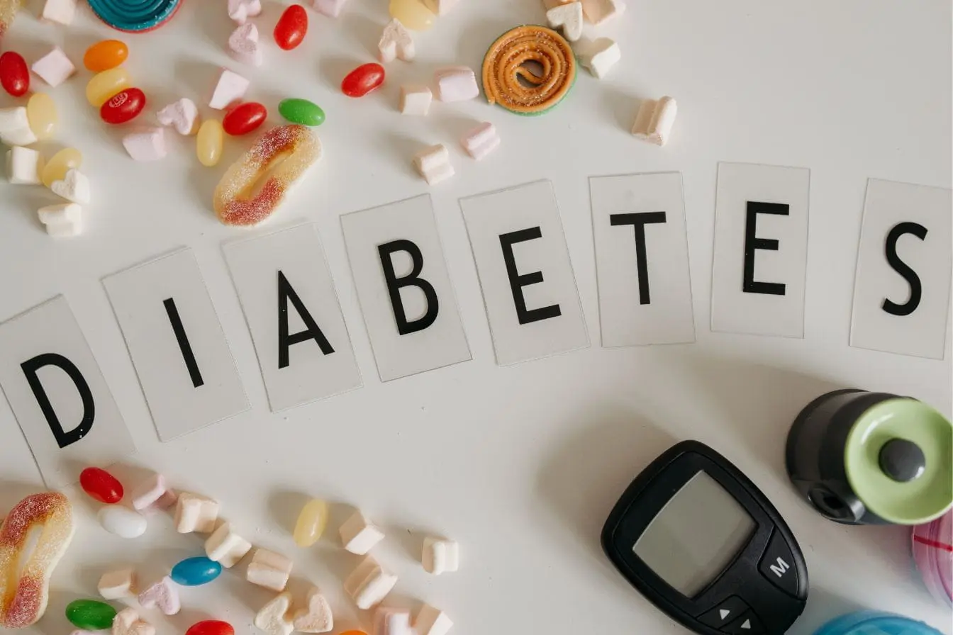 Prévention du diabète de type 2 illustrée par un lecteur de glycemie et des bonbons sucrés entourant le mot diabetes formé avec des lettres imprimées