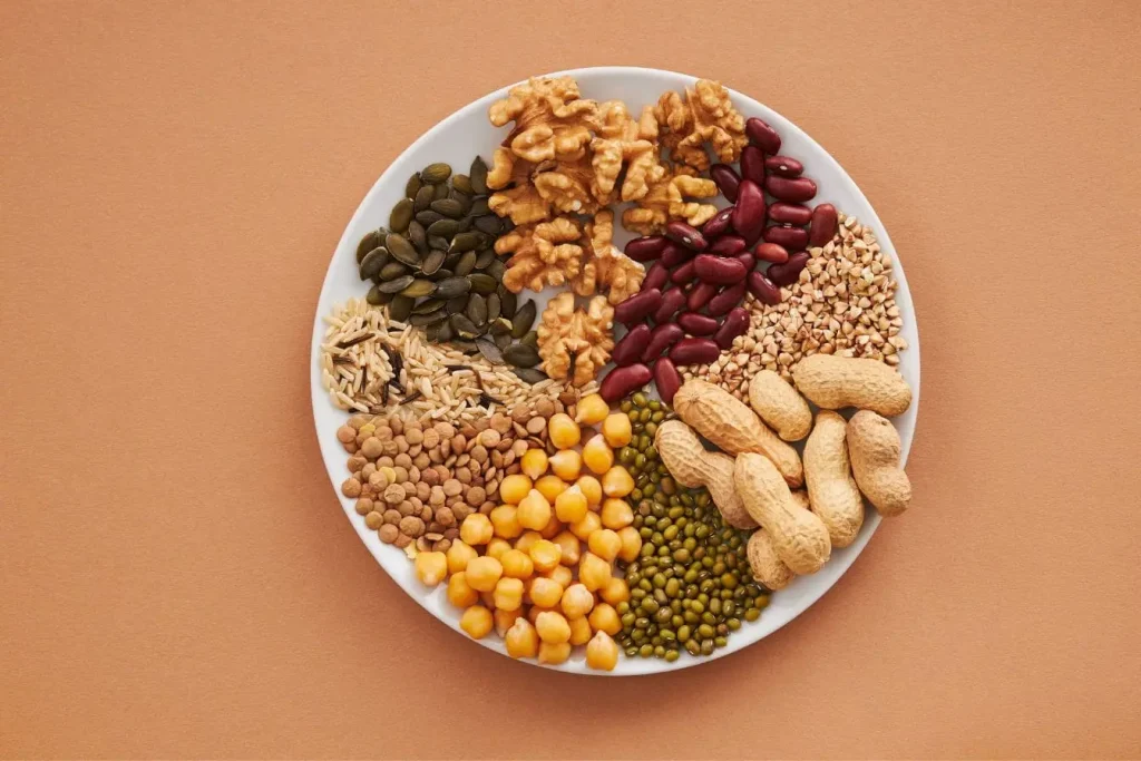 Assiette blanche remplie de noix, légumineuses et graines, reflet d’une alimentation riche en nutriments pour prévenir la neuropathie périphérique.