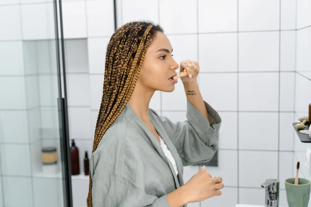 Gros plan sur individu devant lavabo brossant soigneusement ses dents, image claire illustrant la prévention d’une langue blanche.