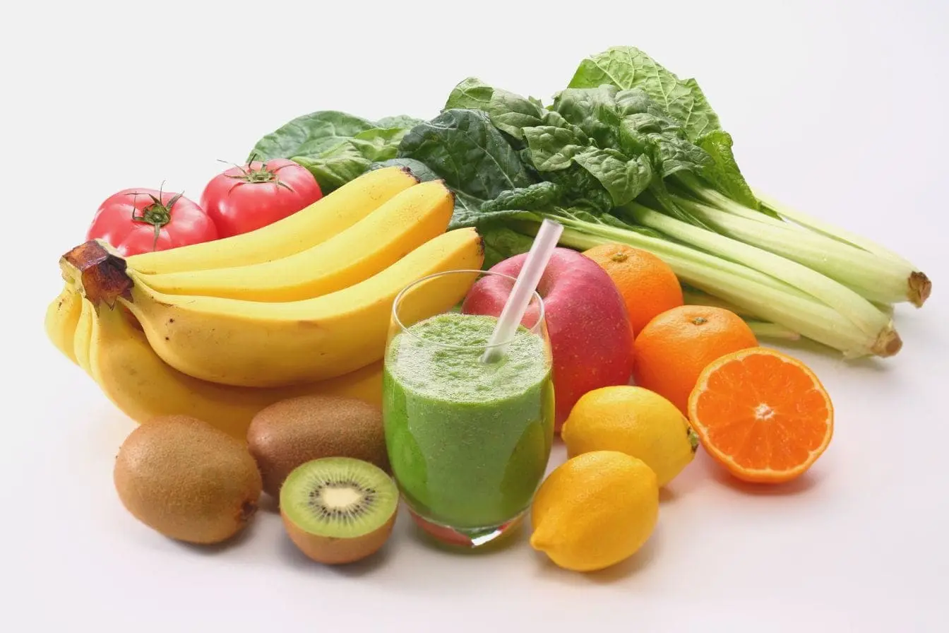 Assortiment coloré de fruits et légumes frais sur surface blanche, reflet des meilleures sources alimentaires de vitamine E.