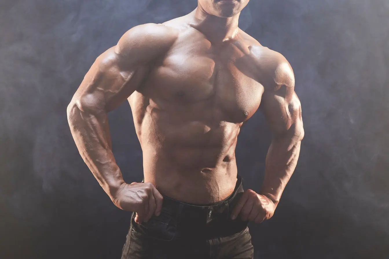 Torse musclé mis en valeur sur fond sombre, une image qui illustre l’importance des facteurs physiques et hormonaux dans la baisse de libido masculine