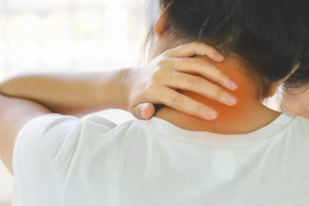 Une jeune femme se massant la nuque pour apaiser une douleur cervicale intense liée à un torticolis et découvrir des remèdes rapides et gestes efficaces.